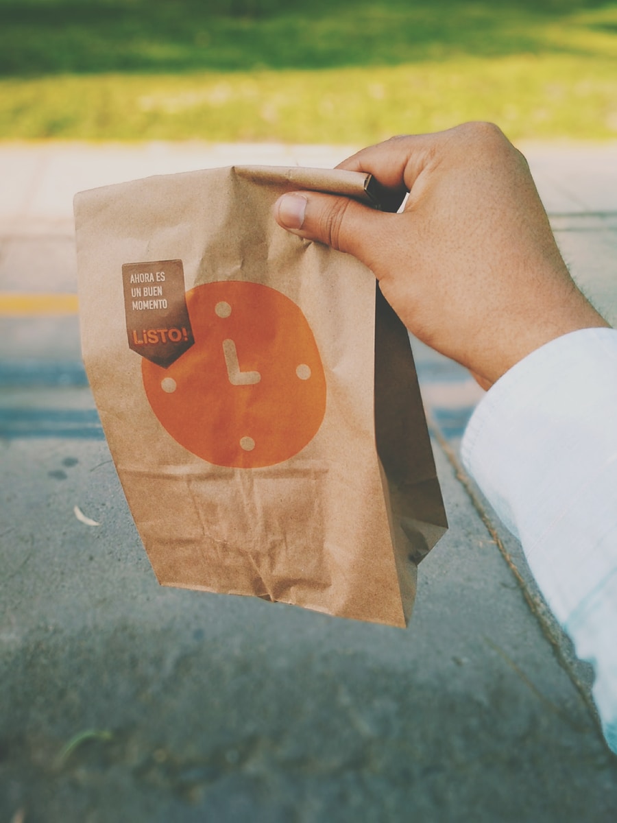 person holding brown paper bag